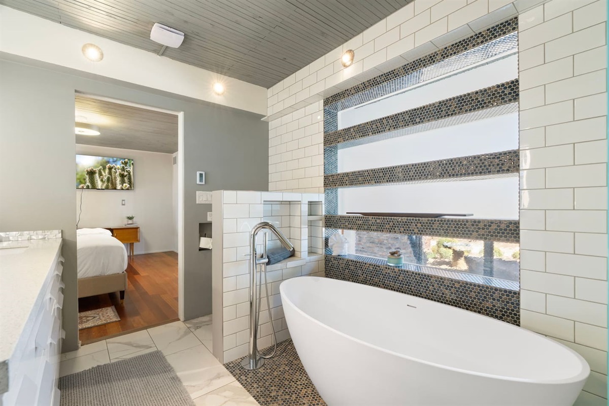 Spa-inspired bathroom featuring a sleek freestanding soaking tub, modern tile finishes, and a bright, airy design for ultimate relaxation.