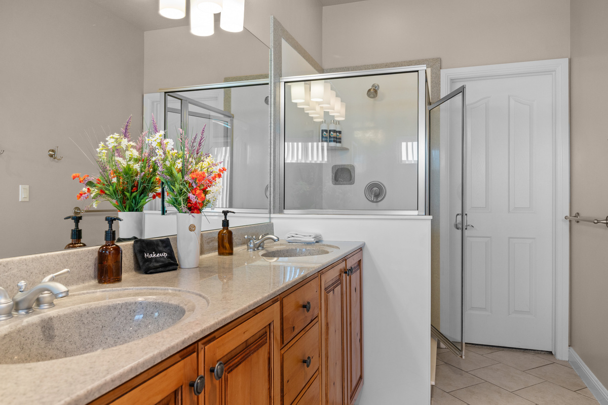 The spacious primary bathroom features a dual-sink vanity, walk-in shower, and plenty of room to get ready and unwind in comfort during your stay.