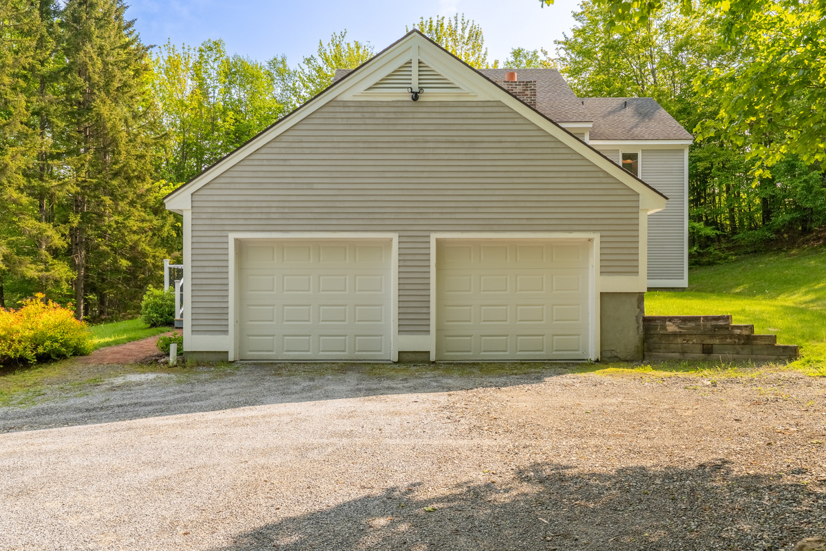 Detached garage with gravel parking for several vehicles at this Stratton area ski house