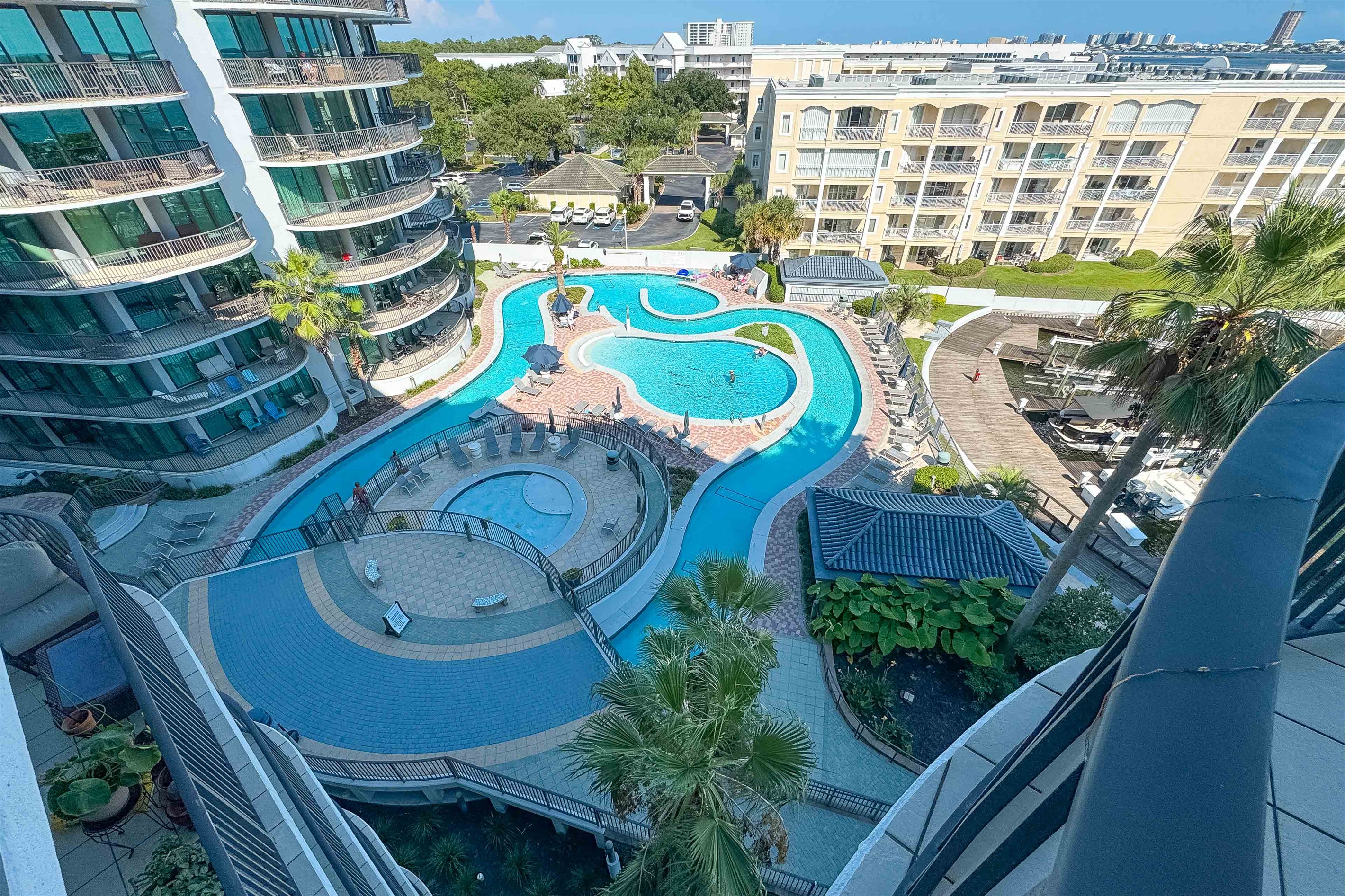 Dive into a life of leisure. This stunning view showcases the resort-style lazy river and pools, surrounded by lush landscaping and luxurious residential buildings. It’s more than a home; it’s an escape.