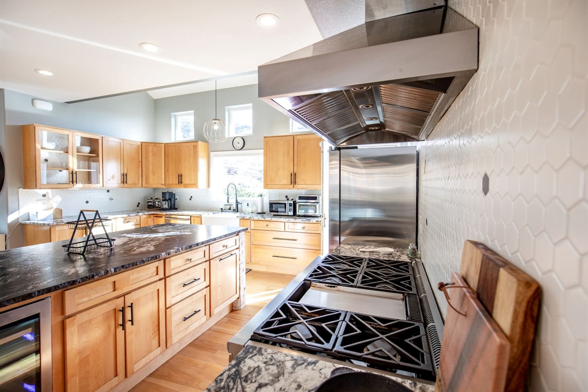 Cook like a pro on the sleek gas range with a stylish hood, perfect for preparing delicious meals in a modern kitchen.