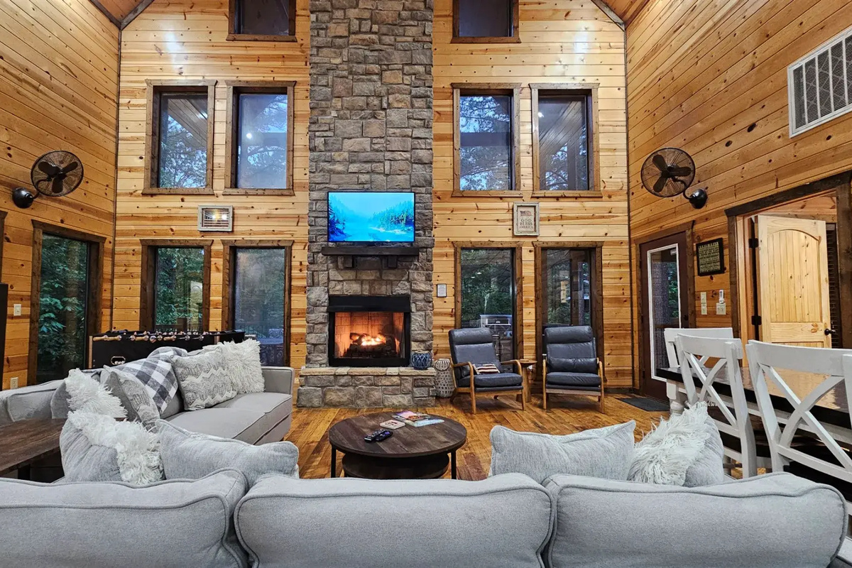 Living Room: Elegant stone fireplace and expansive windows invite nature inside for a memorable stay!