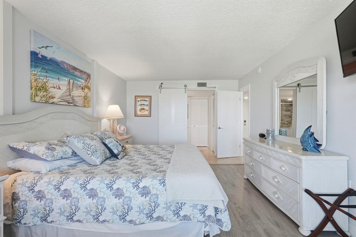 The master bedroom features a king-sized bed and a calming atmosphere, perfect for relaxing after a day at the beach or exploring the city. It offers stunning Boca Ciega Bay views with sunrise and sunset, abundant natural light, and a private en-suite bath