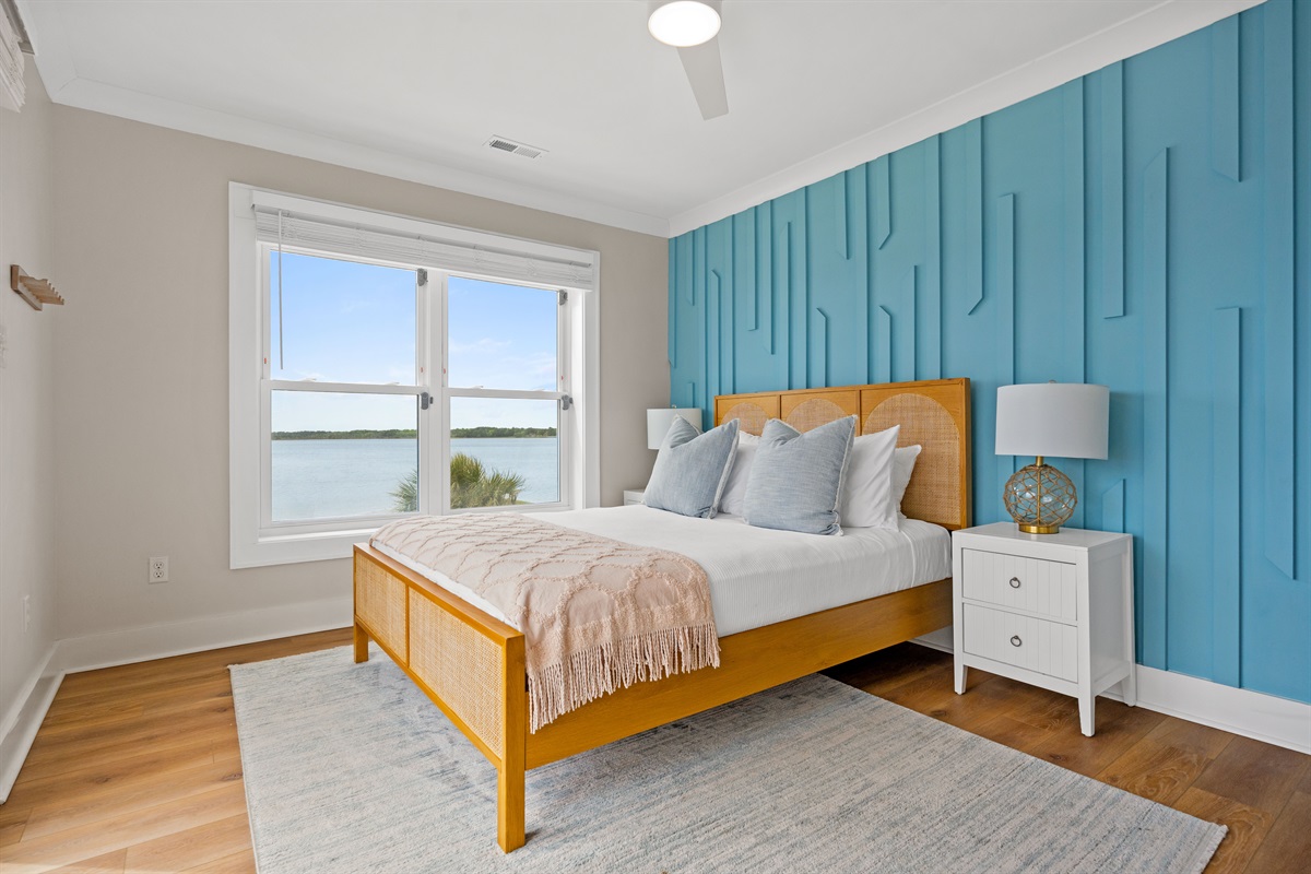 Bright and airy queen bedroom with serene water views and stylish coastal-inspired design