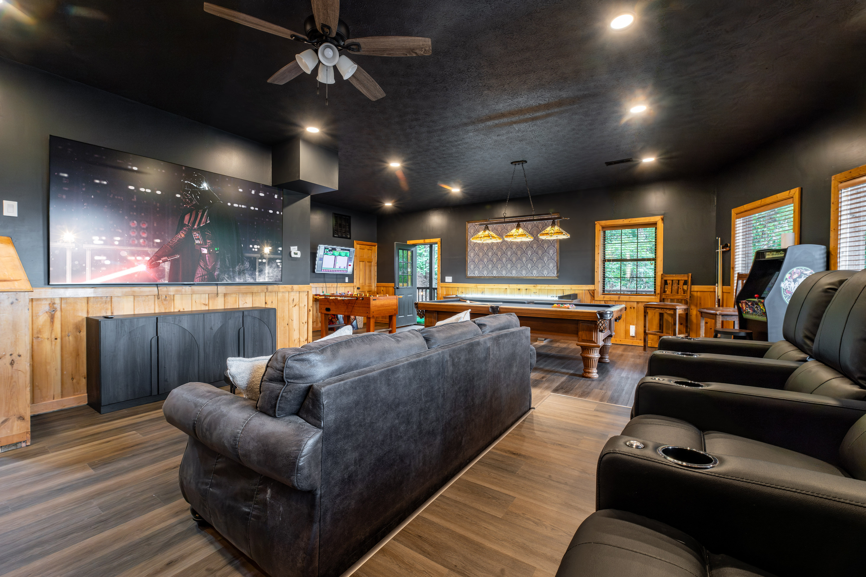 Theater room with large 98 inch TV and comfortable reclining theater seats.