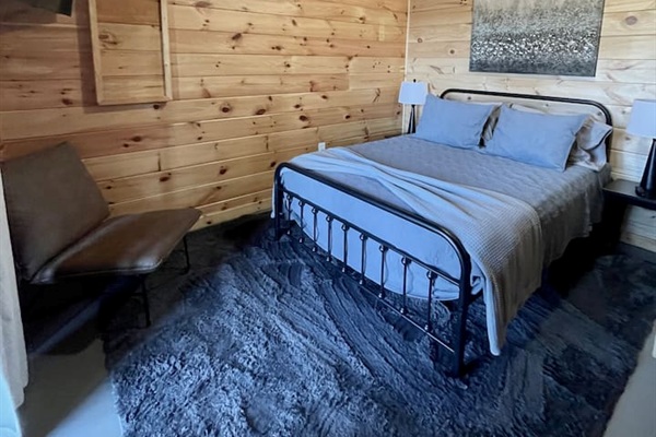 Basement bedroom has a queen bed and steps out to the lower patio with a bench swing and infrared sauna!