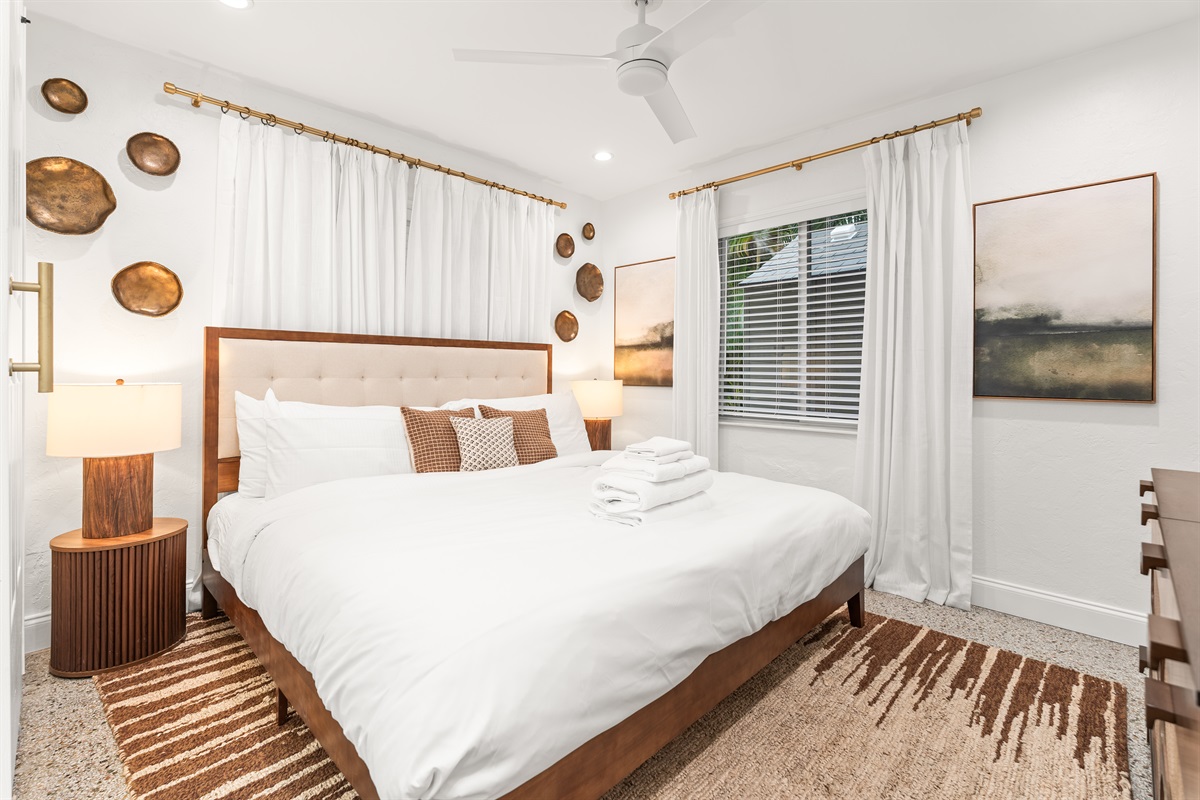 Drift off in this serene coastal king suite, where soft linens, warm wood tones, and breezy light create the perfect beachside retreat.