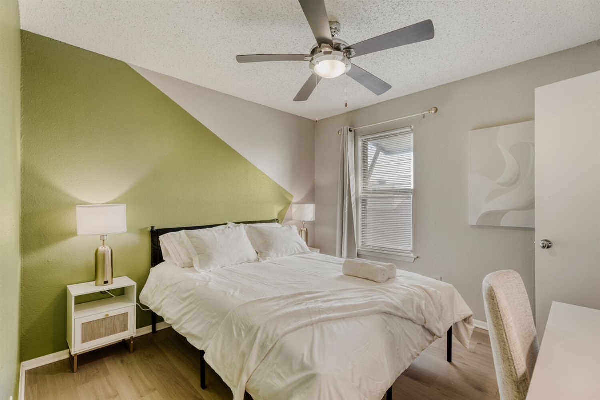 Cozy bedroom with modern decor and a calming green accent wall.