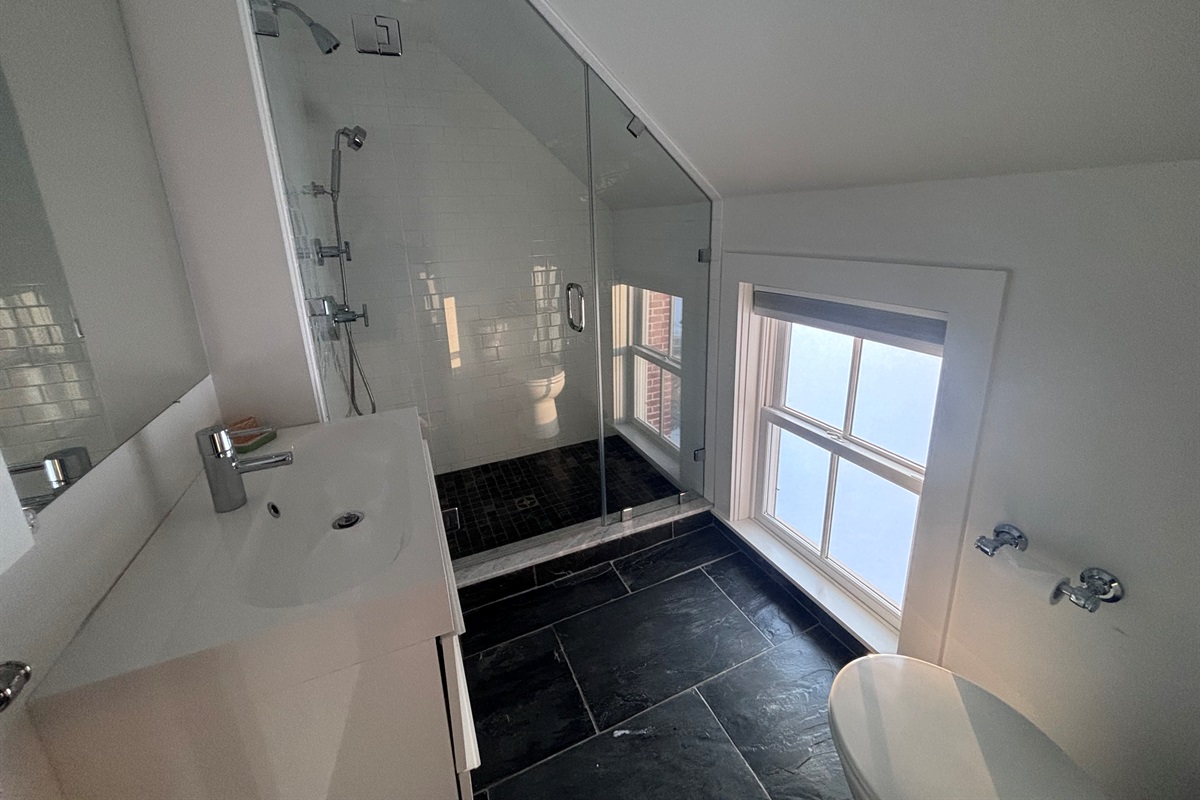 Modern bathroom with walk-in shower, sleek tile, and spa-style finishes.
