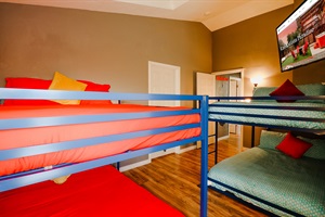 A bunk bedroom that cleverly maximizes space, offering a cozy and functional sleeping solution for multiple occupants, ideal for siblings or guests.