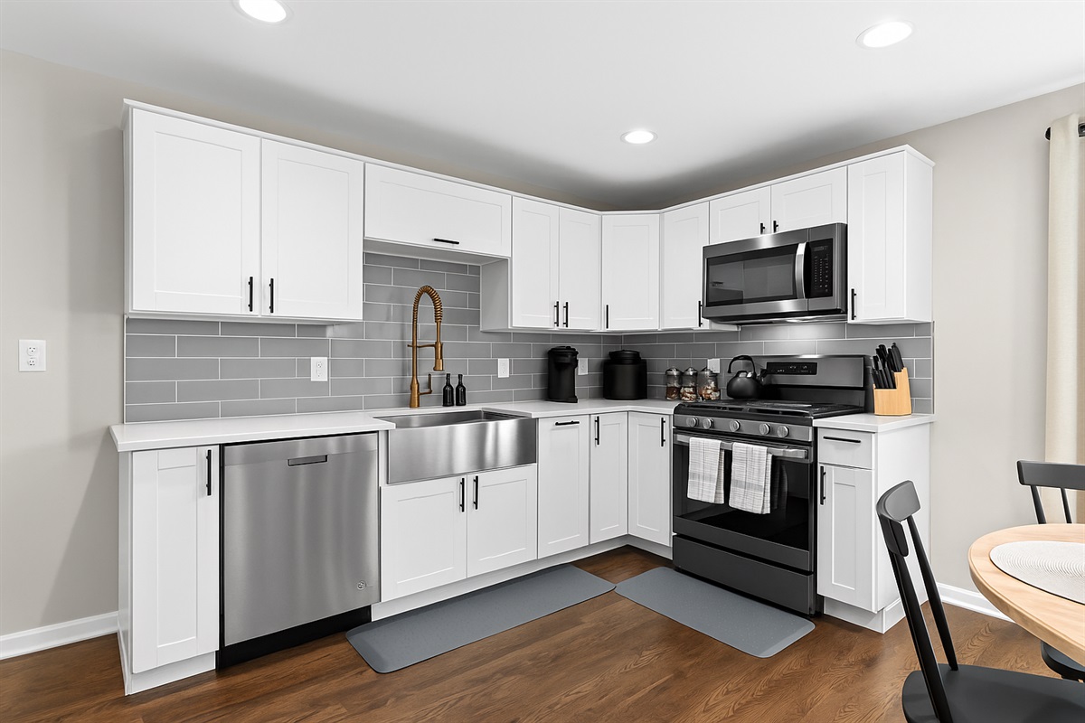 Fully equipped modern kitchen with stainless steel appliances, farmhouse sink, and sleek finishes—ready for home-cooked meals or quick bites.