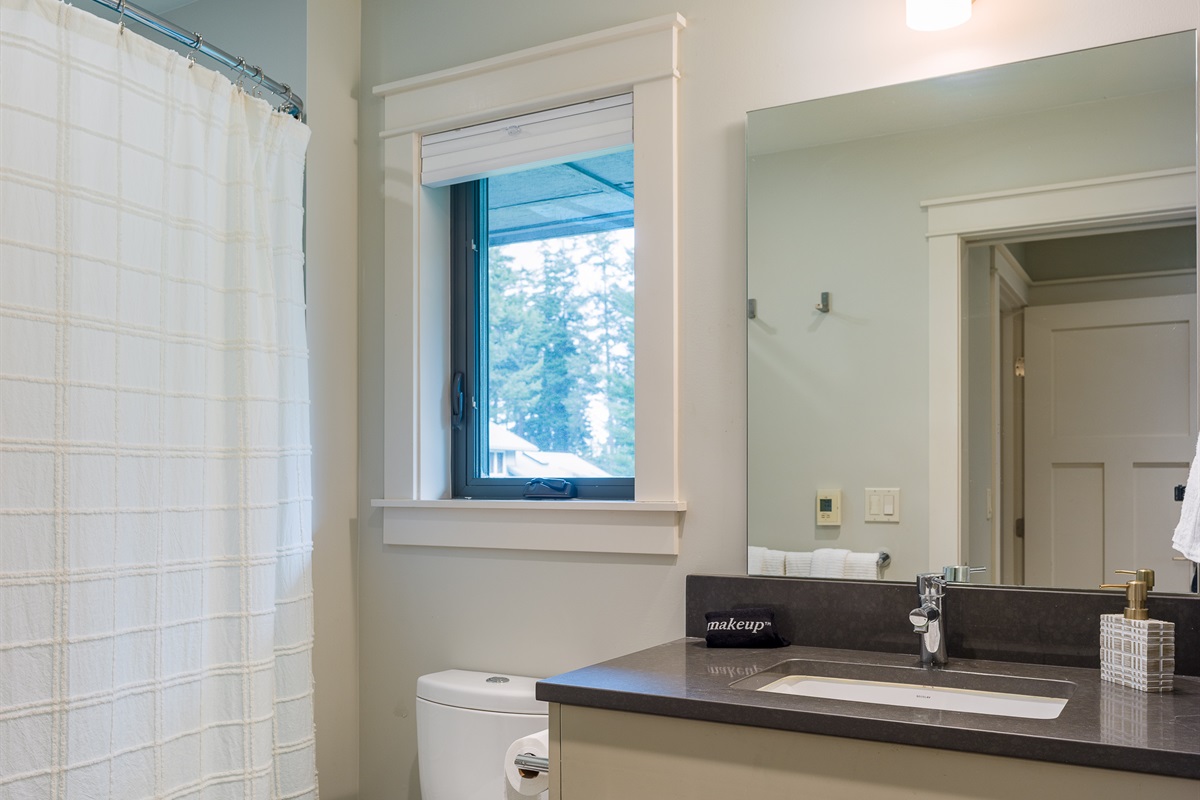 Meticulous and simple, this bathroom offers privacy and convenience located within the second primary suite.