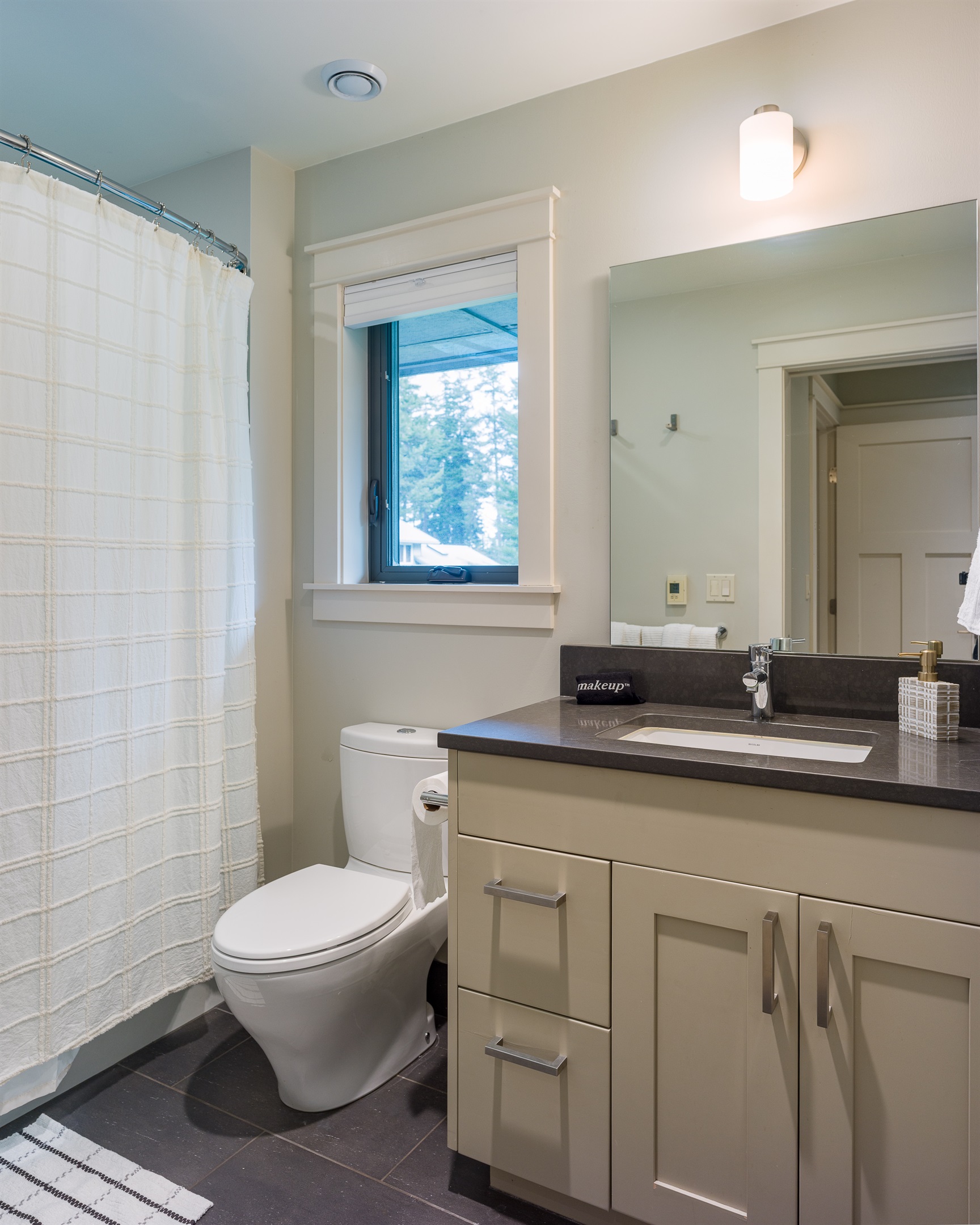 Meticulous and simple, this bathroom offers privacy and convenience located within the second primary suite.