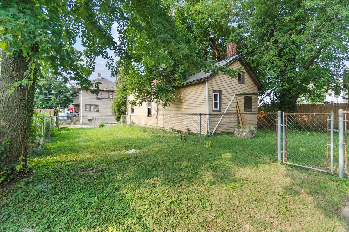 Back exterior of the house surrounded by trees.
