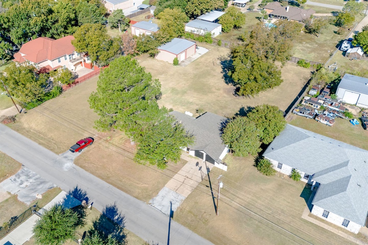Expansive lot and charming neighborhood setting — see the full layout of this family-friendly Grand Prairie stay with open yard and tree-shaded driveway.