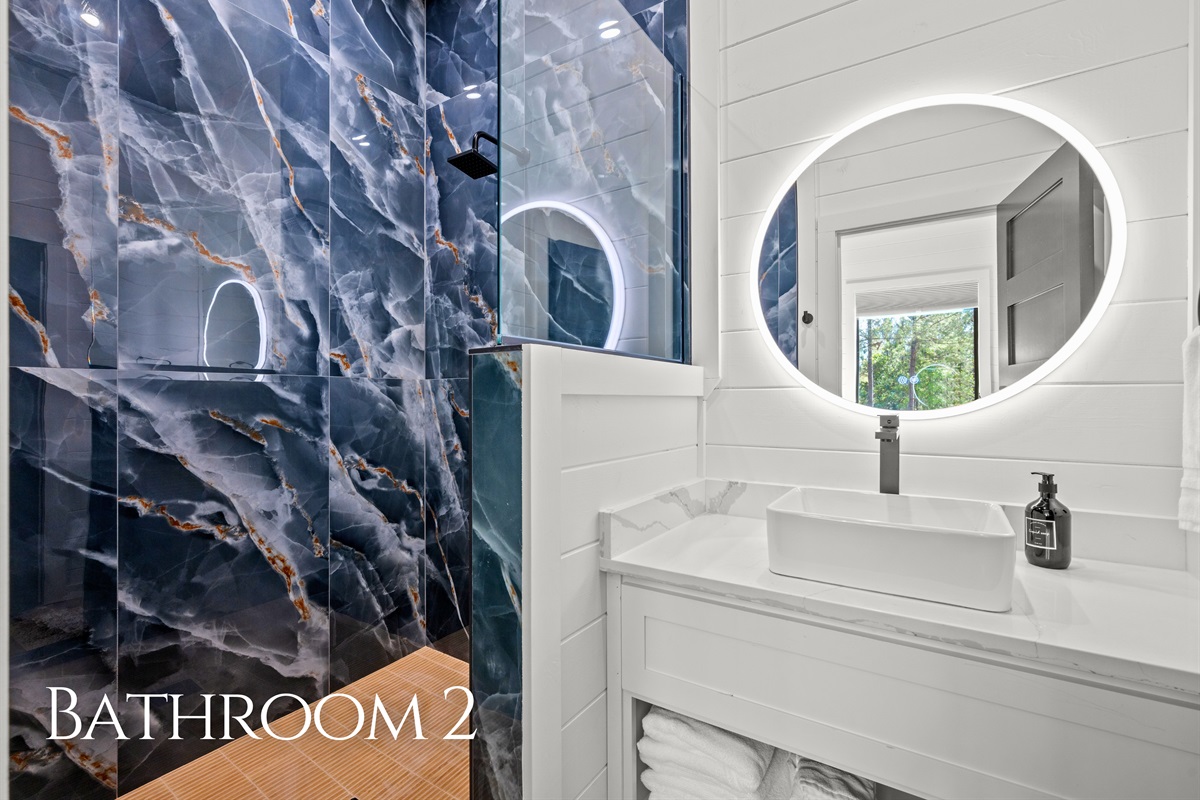 Bold tile details, modern fixtures, and warm lighting come together to create a bathroom space that feels polished while still remaining practical for guests.