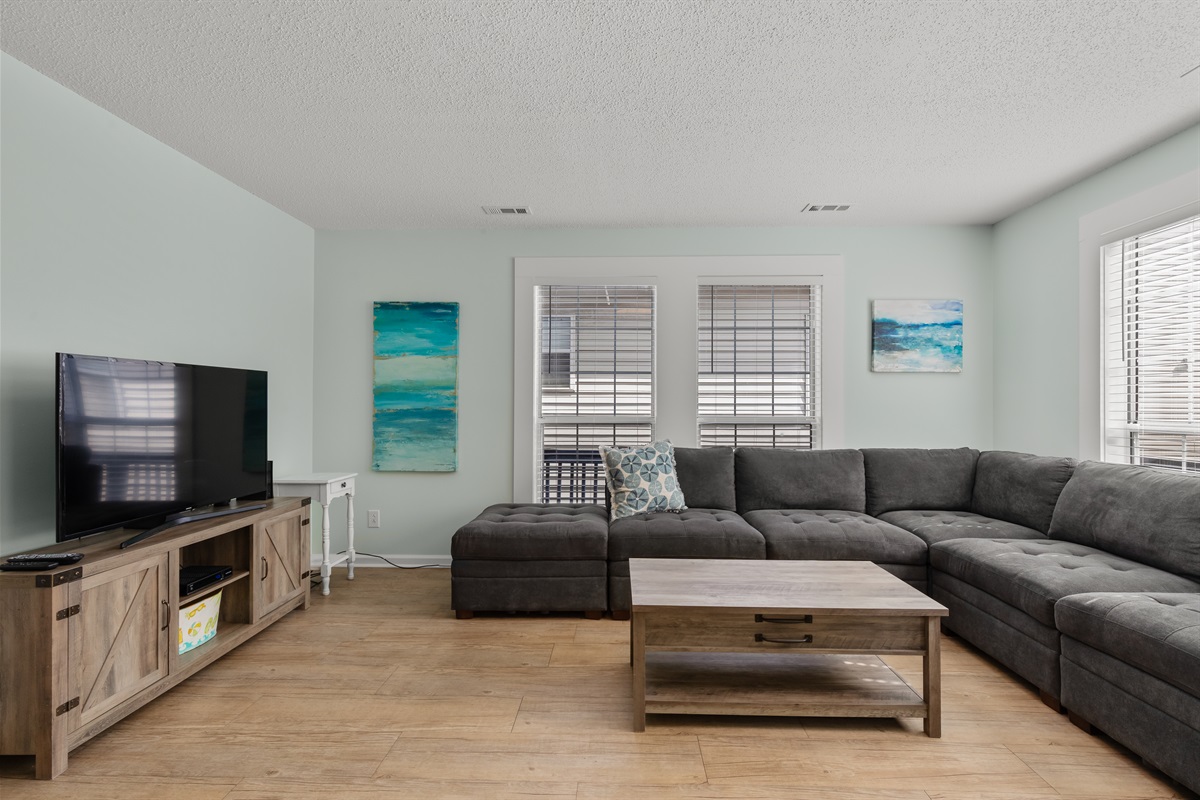 Large living room with plenty seating and smart TV
