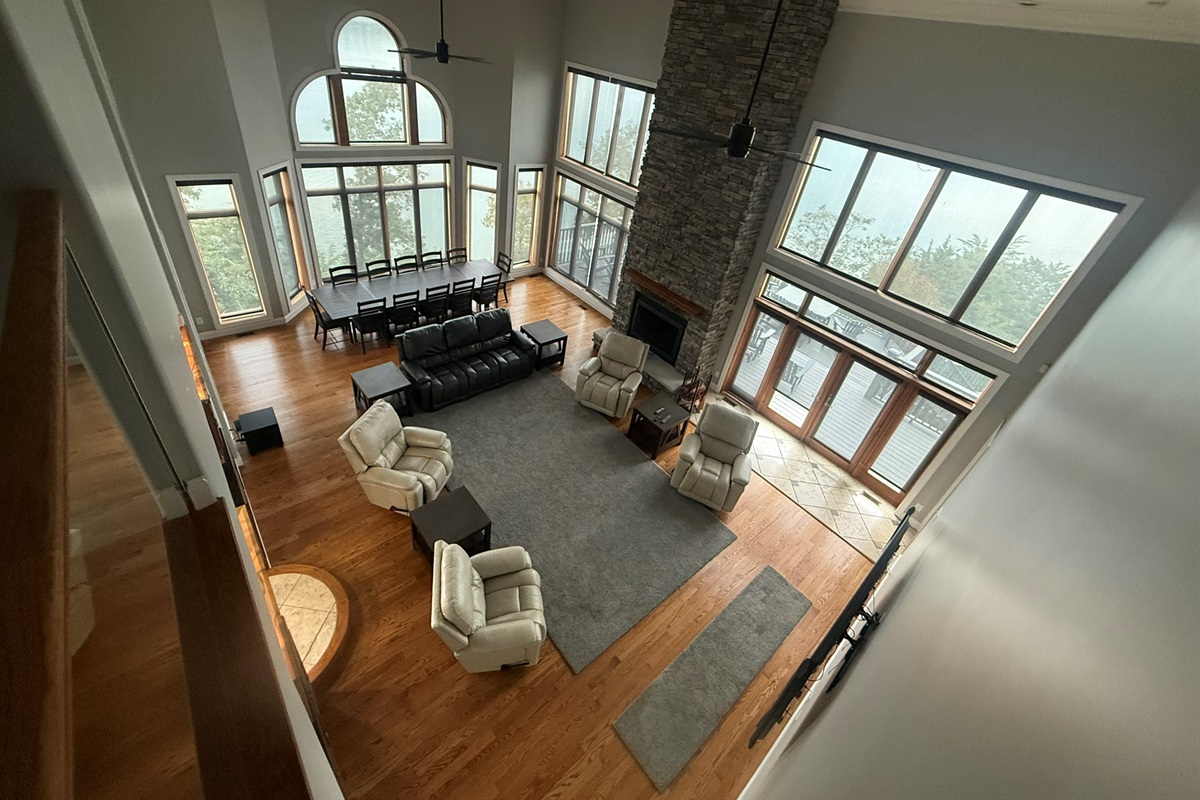 Living room with 20 ft ceiling, large windows with full view of Douglas Lake and Mountains on multiple sides, with doors to 2 porches (one out back and one next to the kitchen)