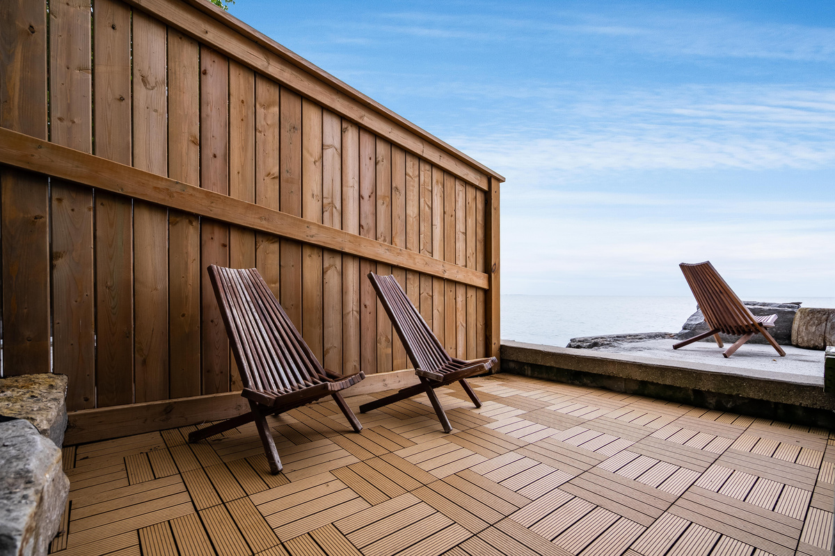 Peaceful waterfront deck with lounge chairs and panoramic lake views.
