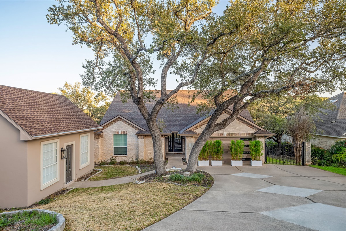 Peaceful front driveway shaded by mature trees with plenty of parking space.