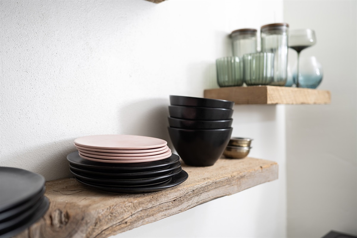 Open shelving stocked with dining essentials for your stay.