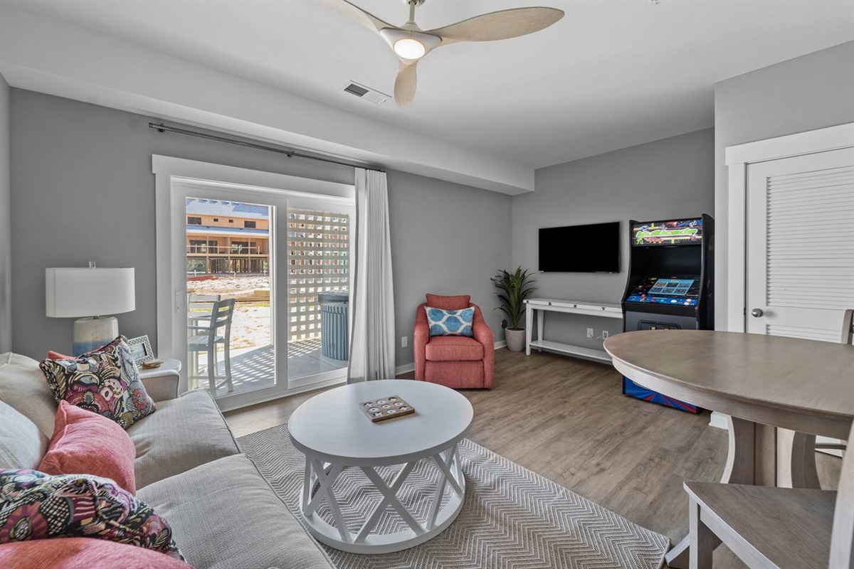 Ground floor living room with couch, arcade, and access to the hot tub
