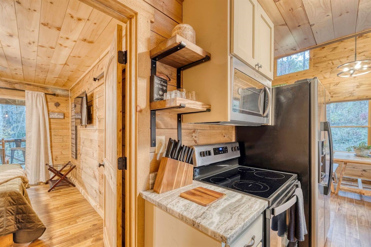 Our cabin's kitchen area boasts cleanliness and charm, surrounded by the comforts of home. Enjoy the convenience of modern amenities amidst the rustic serenity of your woodland escape