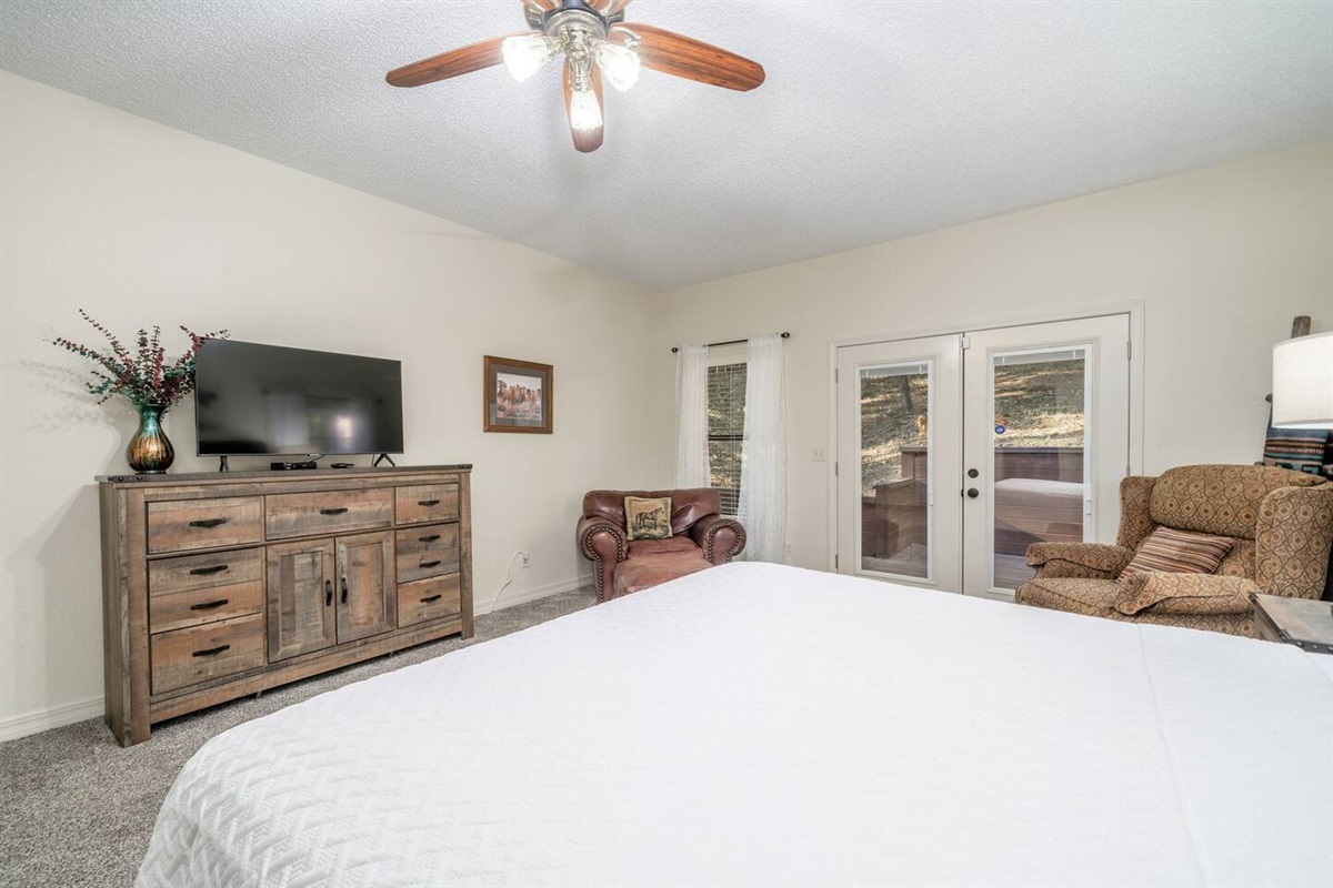 Master bedroom includes desk, smart tv, sofa chair, ottoman, a rock/recliner, iron/ironing board, travel crib, and luxury private bath with separate tub and standing shower.