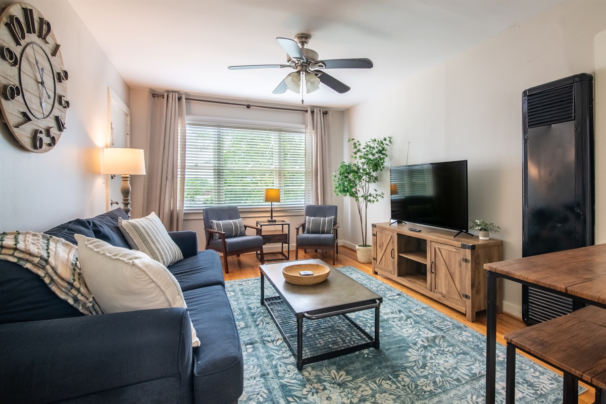 Bright and cozy living room with comfortable seating and a smart TV — perfect for relaxing after a day out.