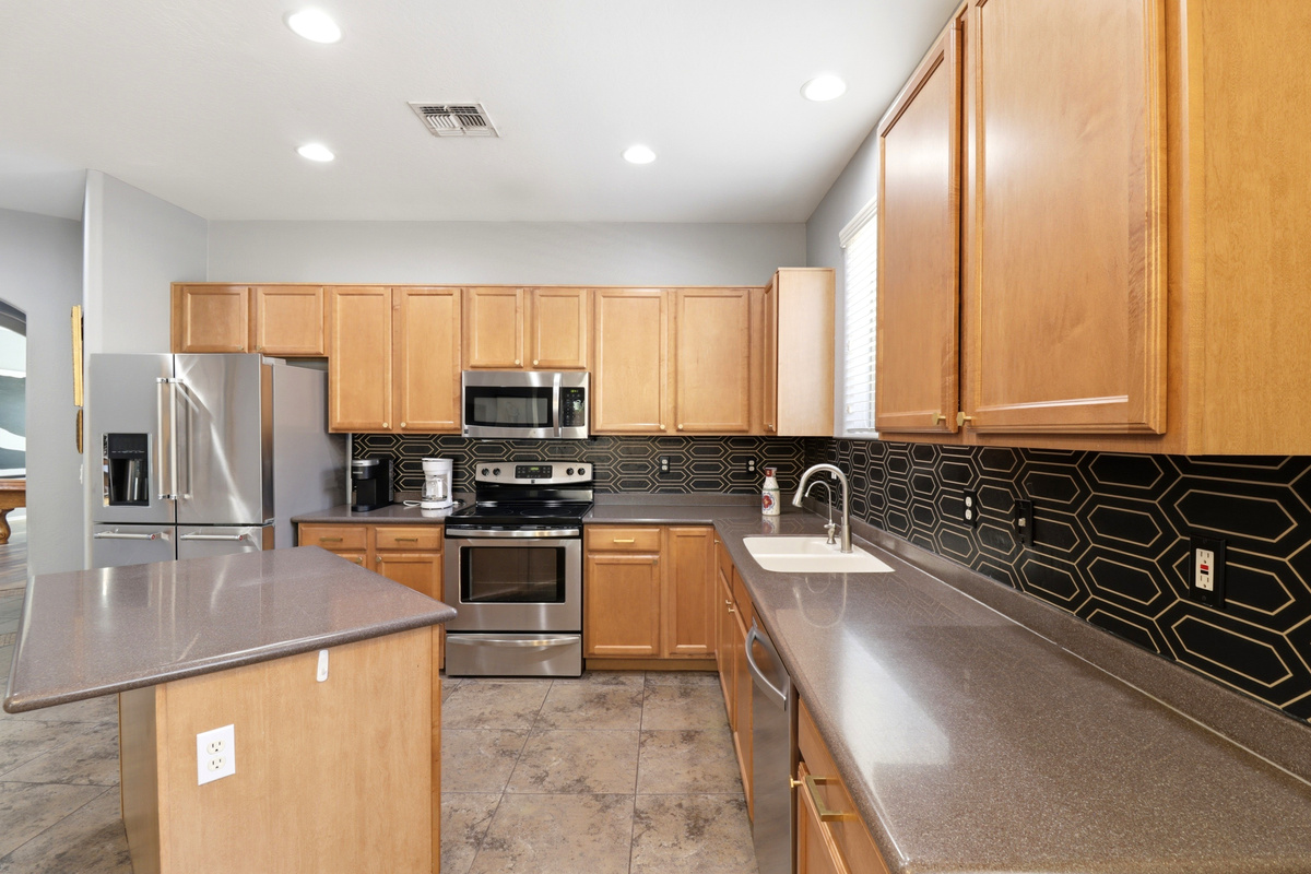 Kitchen with a center island, full appliances, and plenty of space for cooking or serving meals.
