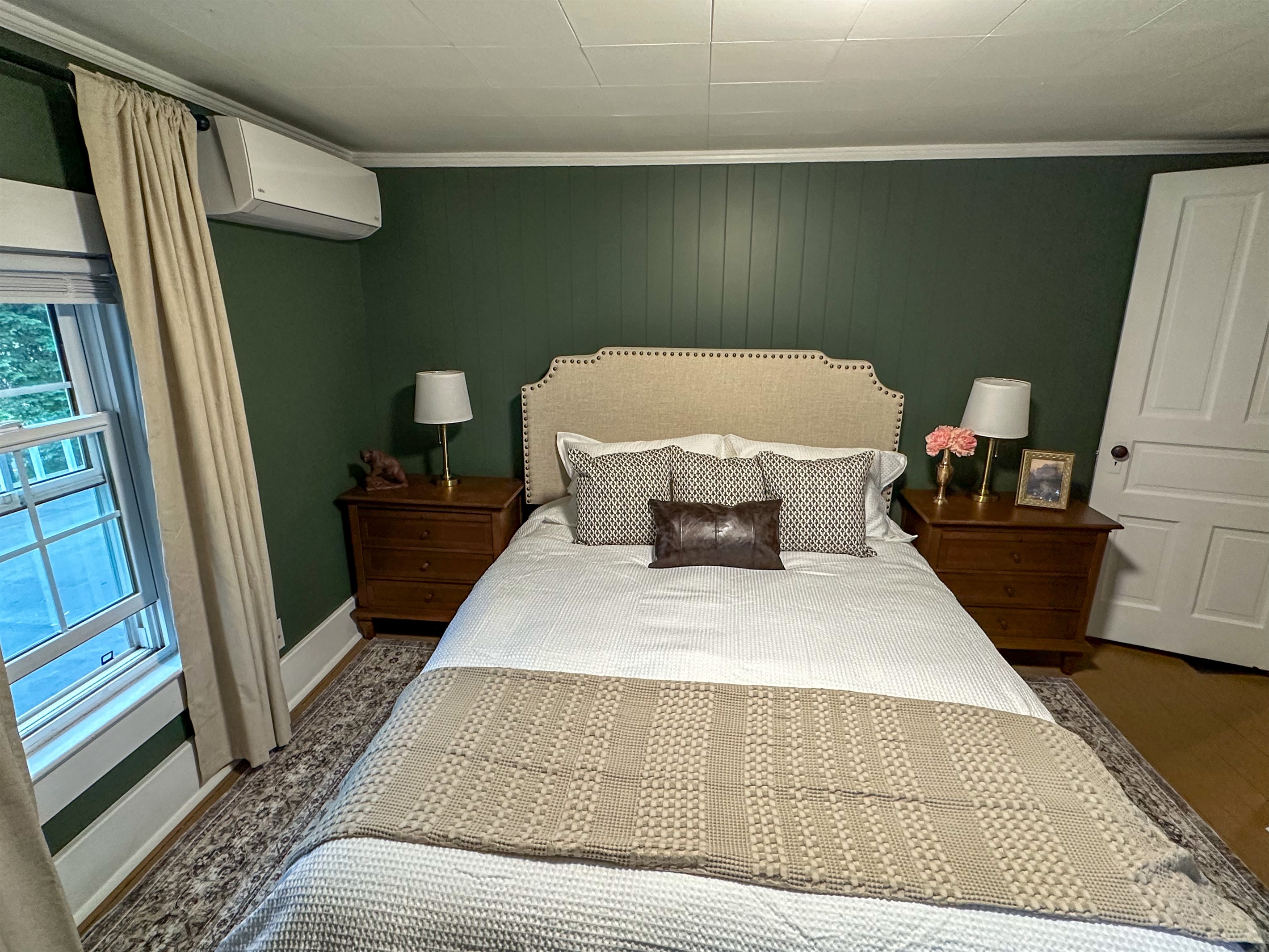 Retreat to a cozy, elevated escape where rich green walls, warm wood tones, and crisp white bedding create the perfect blend of comfort and style. We keep all of our beds dressed in fresh white linens so you can instantly see everything is sparkling clean.