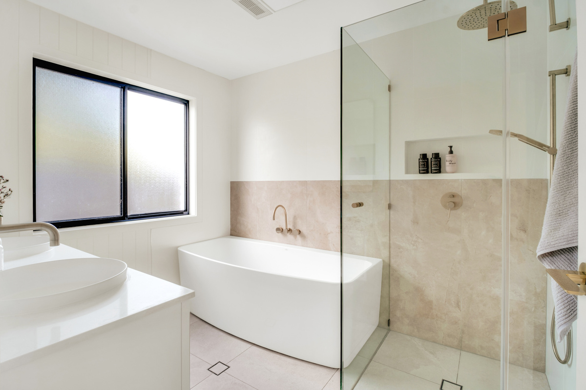 Designed for relaxation, this stylish bathroom offers both a deep freestanding bath and separate walk-in shower.