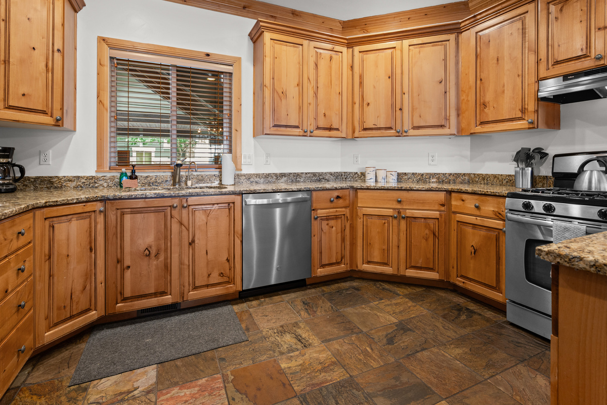 Fully equipped kitchen with granite countertops, stainless steel appliances, and convenient bar seating.