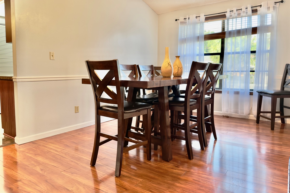 The rich, cherry-toned wood flooring creates a welcoming ambiance, while the adjoining wood-paneled accent wall adds warmth and texture.