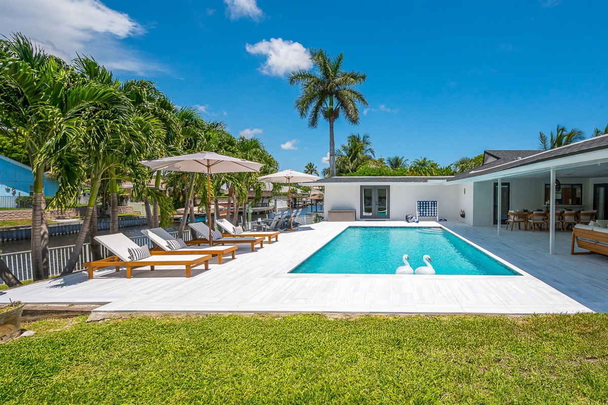 Spend your days lounging by the shimmering pool, dining al fresco under the covered patio, and unwinding in stylish outdoor living spaces—all set against a serene lakefront backdrop with private dock access