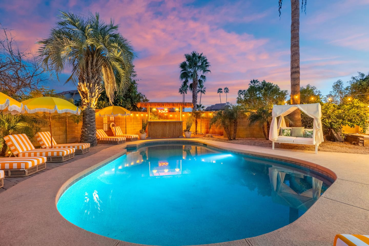 Resort-style pool at sunset with loungers, umbrellas, and desert views—your private oasis for swimming and stargazing.