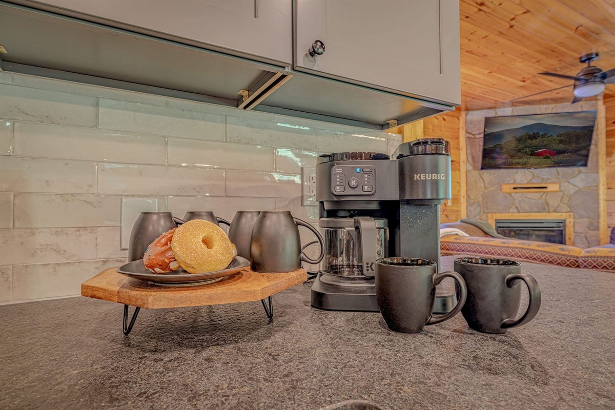 Granite kitchen island with 6-stool seating &mdash; the heart of the main floor. Fully stocked and ready on arrival. Luxury Gatlinburg cabin rental for groups.