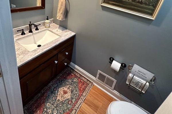 3rd Bathroom which has a sink and toilet (1/2 bath) on the first floor next to the kitchen