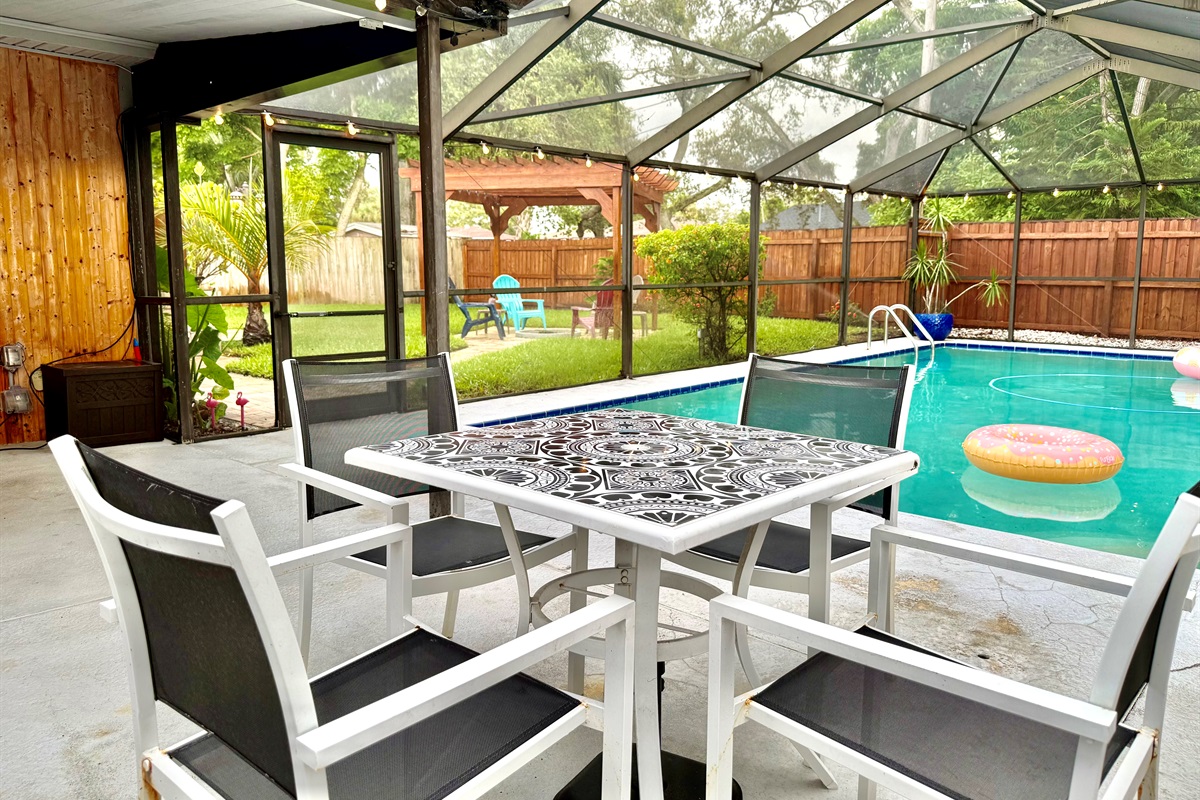 Enjoy meals, games, or morning coffee in this covered lanai just steps from the sparkling pool—bug-free and breezy!