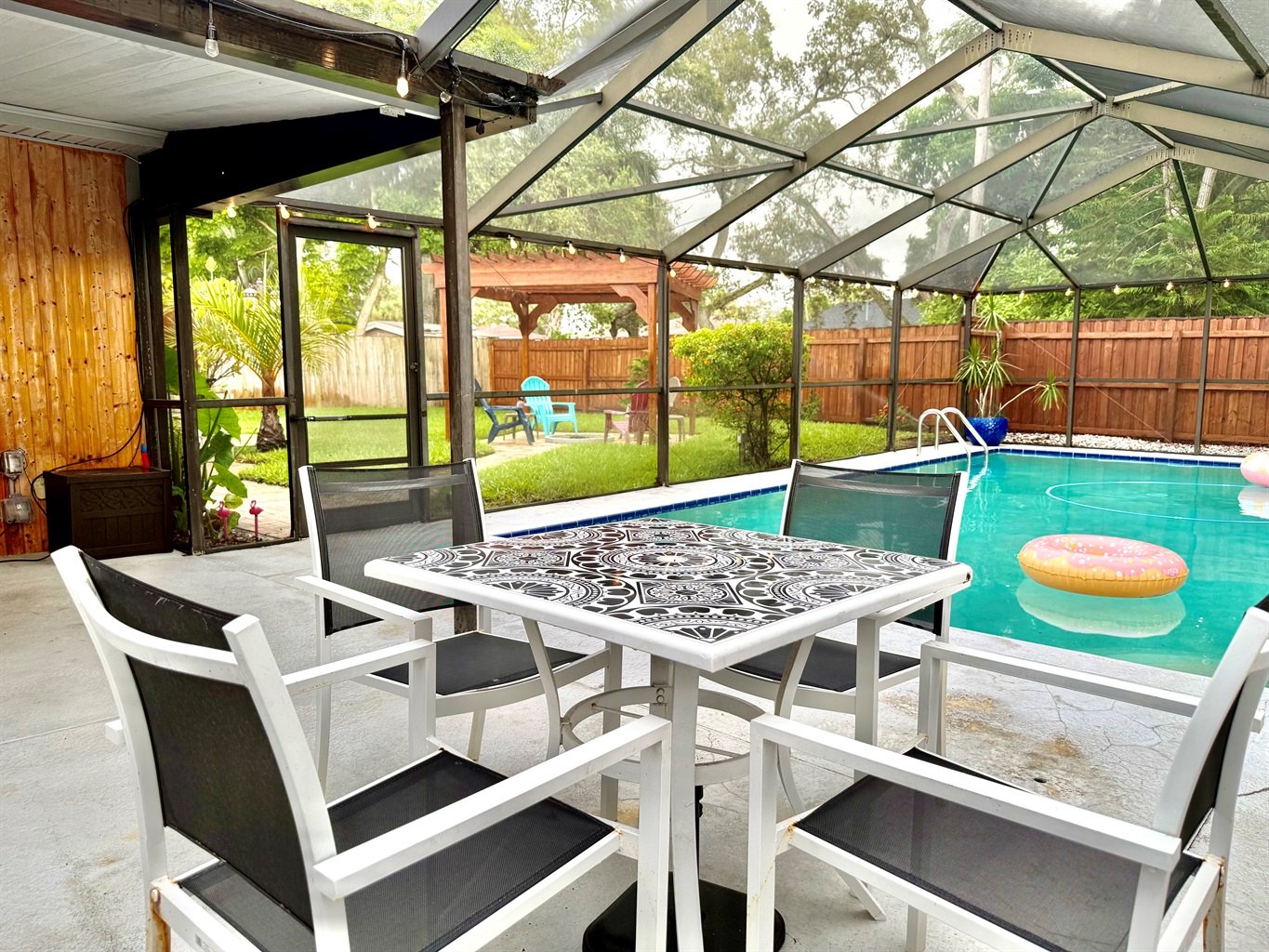 Enjoy meals, games, or morning coffee in this covered lanai just steps from the sparkling pool—bug-free and breezy!