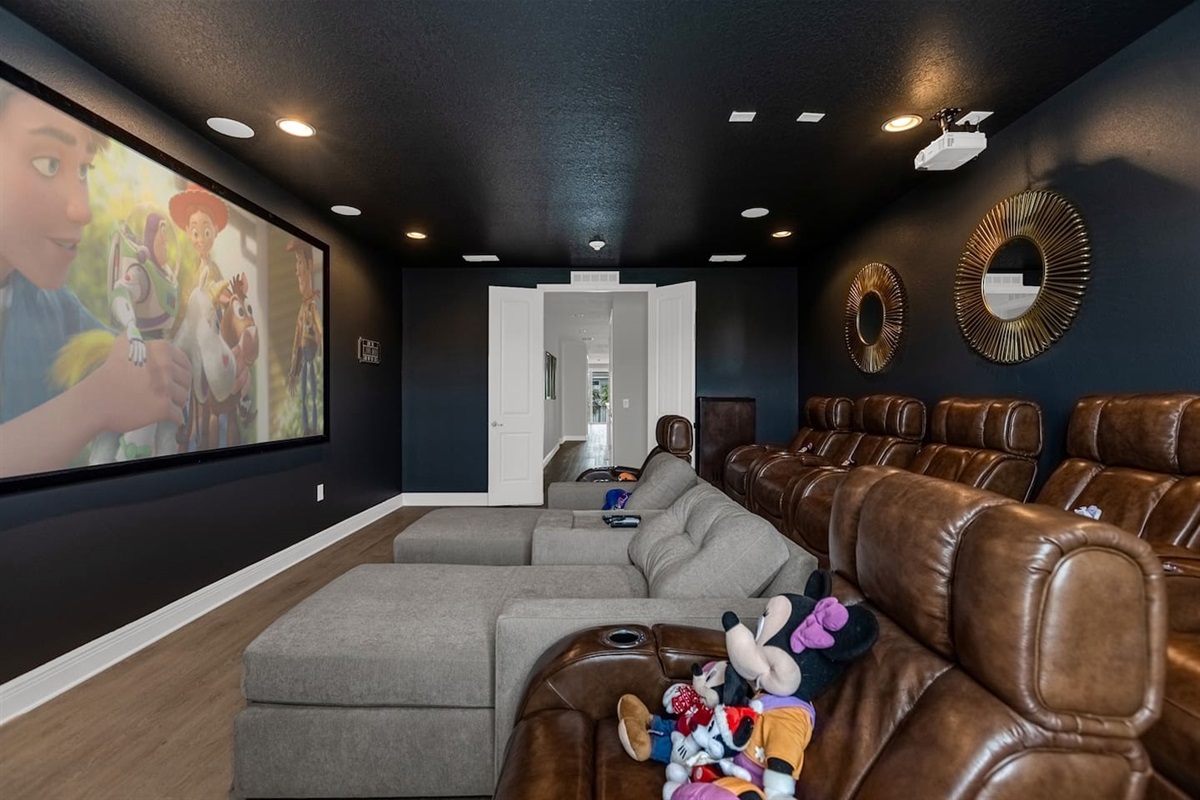 The mini theater is an intimate and inviting space, designed to provide a cinematic experience right at home. The walls are painted a rich, deep burgundy, creating a cozy atmosphere that enhances the cinematic vibe.