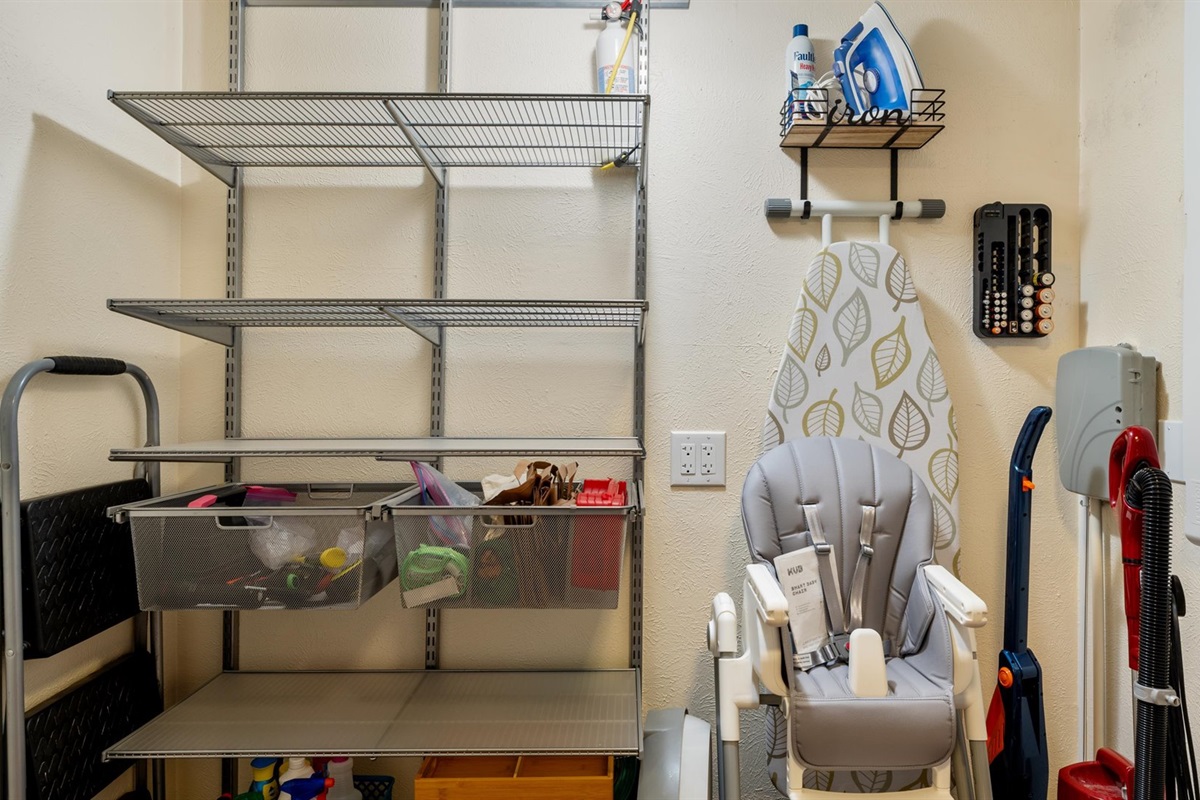 A spacious pantry for guests to store their dry goods and kitchen essentials. Well-organized with plenty of shelving, it also holds useful extras like a high chair, ironing board, and cleaning supplies—offering convenience and flexibility during your stay!