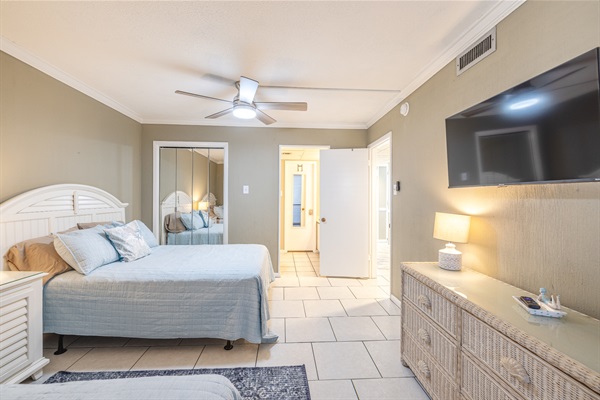Third bedroom with two beds, ceiling fan, smart TV, and access to the 3rd bathroom