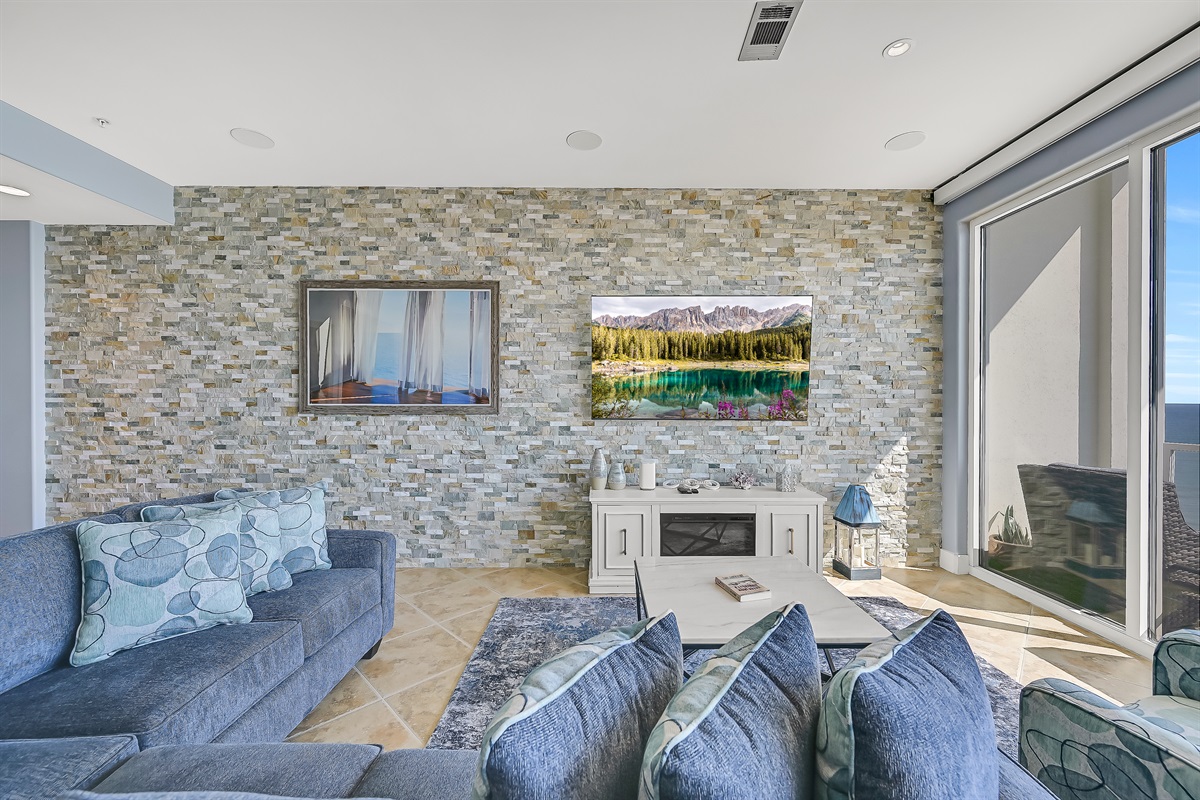 Electronic fireplace, 75 inch Samsung smart TV, sleeper sectional, stone tile