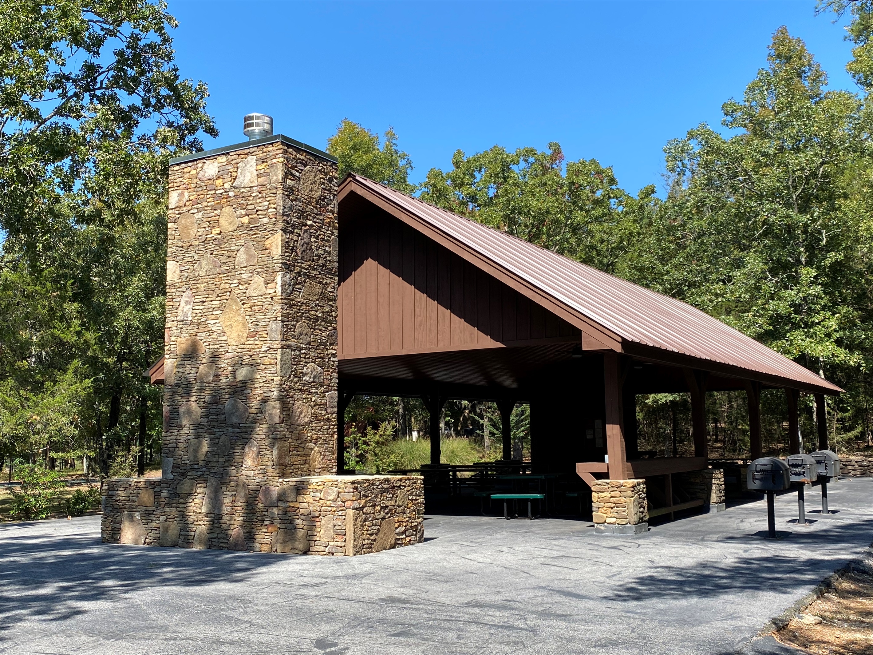 This rustic pavilion is great for hosting outdoor meals or group gatherings, featuring grills and picnic tables.