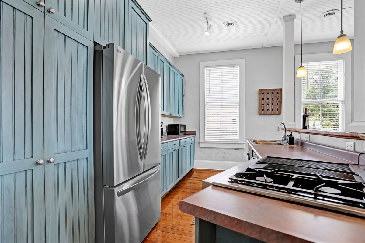 Bold blue cabinetry, stainless appliances, and room to gather around the island.