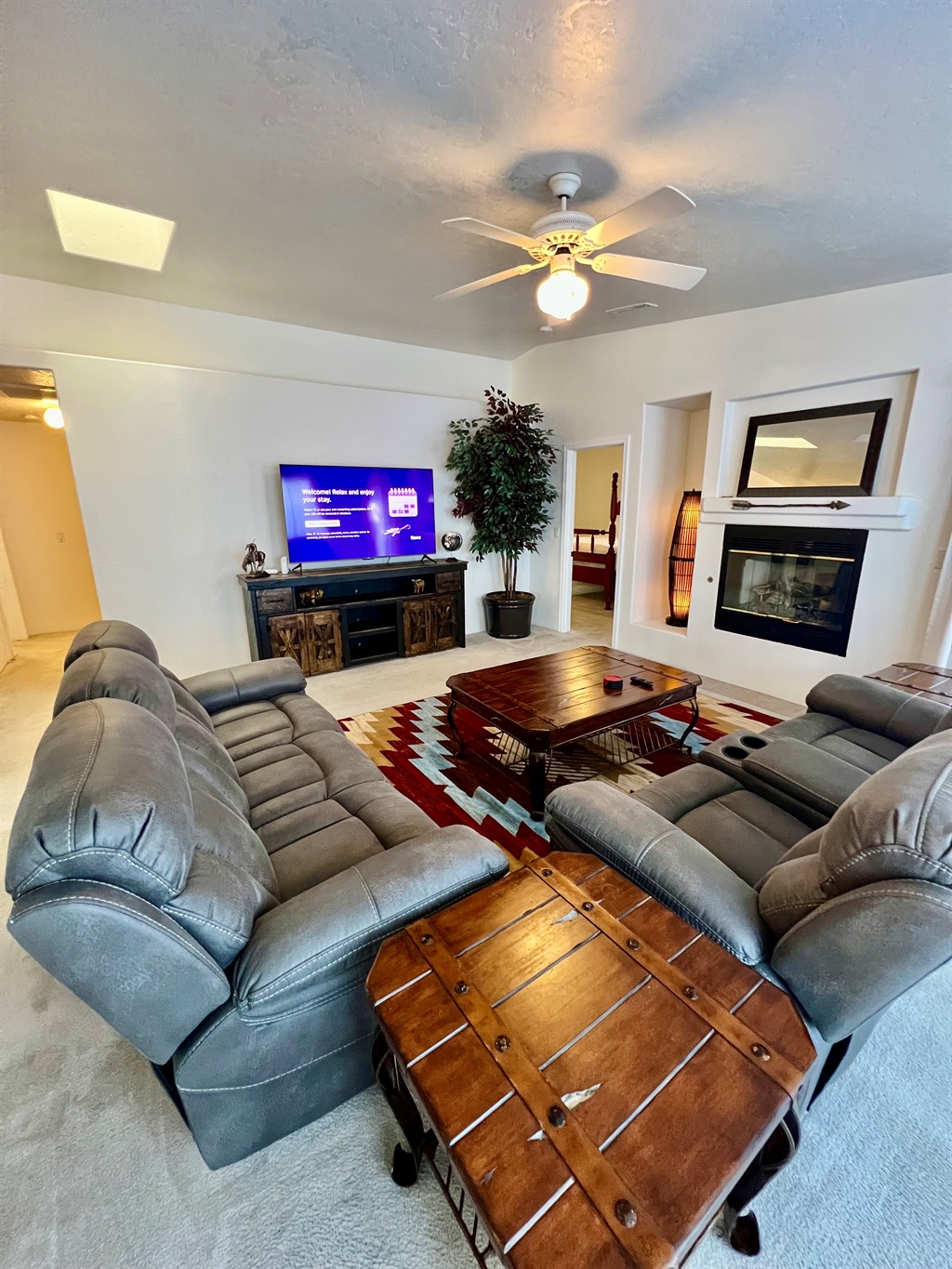 This expansive living room offers plenty of space for everyone to spread out and relax. Whether you're curling up by the fire with a good book, watching a movie on the  60-inch Smart TV, or enjoying game night with friends, this space has it all