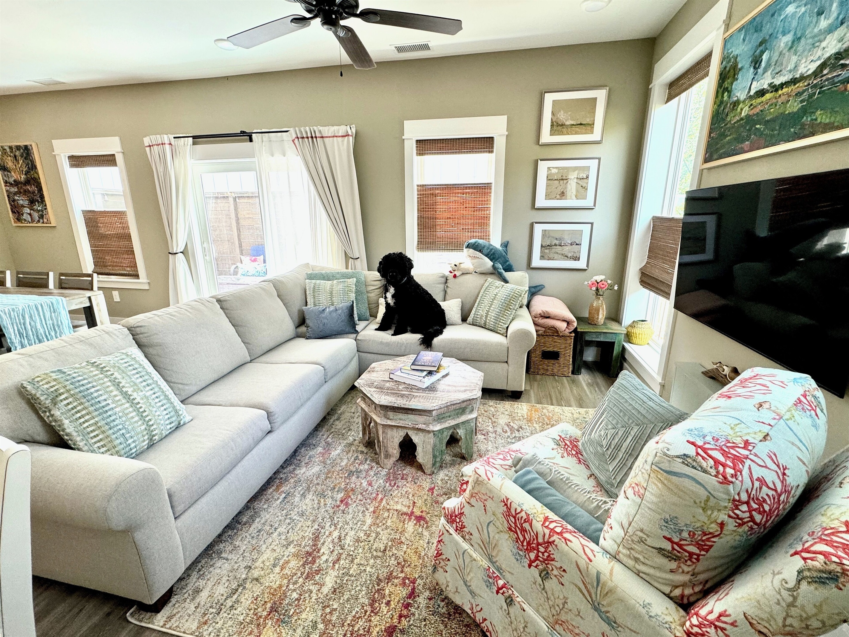 Living space features plush couch, sheer and blackout curtains.