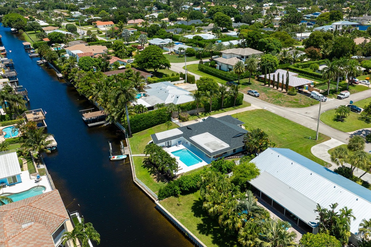 This stunning home sits along a private canal with direct access to Lake Ida, offering a true waterfront retreat. From above, you can see the sparkling pool, lush landscaping, and serene neighborhood that make this property ideal for families and groups.
