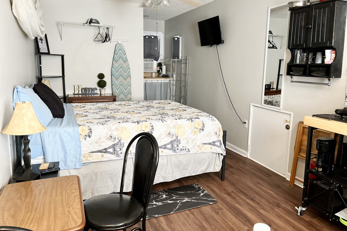 Williams Studio — Queen bedroom with Smart TV, USB charging, sound machine, drawers, shelving, and hangers.